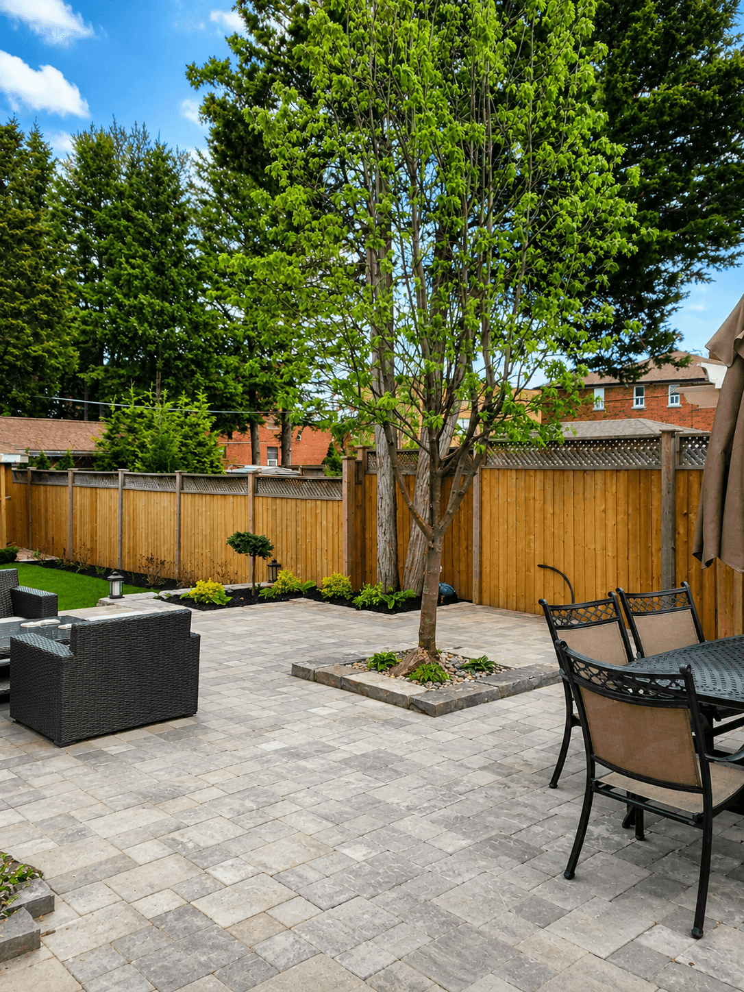Backyard paver patio with furniture and feature tree well